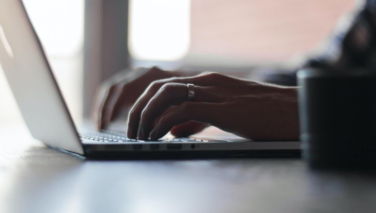 Mains d'un homme écrivant sur un clavier d'ordinateur portable 